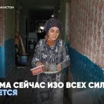 Женщина несет посуду в старом общежитии в Душанбе