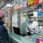 Женщина в маске в аптеке за лекарствами