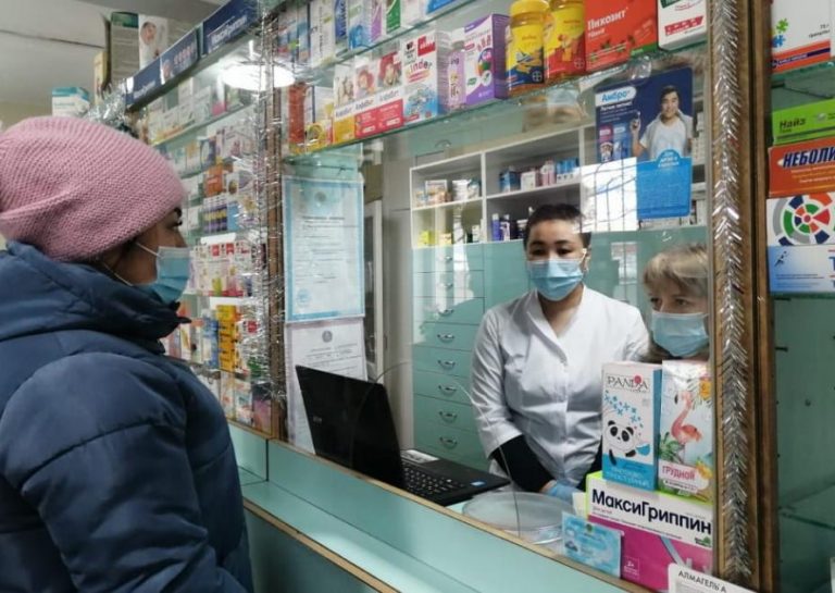 Женщина в маске в аптеке за лекарствами