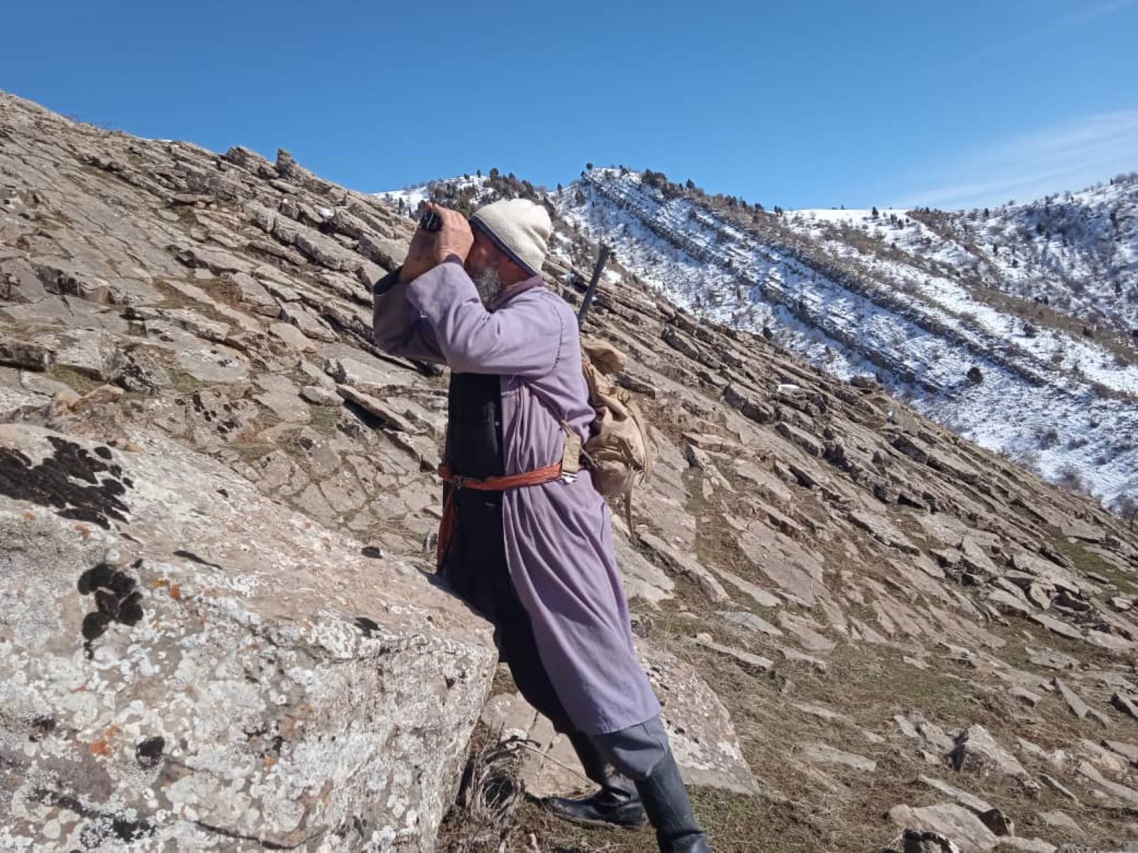 Таджикский охотник смотрит в биноколь
