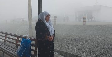 Одинокая женщина стоит на женском мардикорбозоре в Бохтаре в ожидании работы