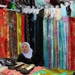 Женщина на рынке Таджикистана продает ткани