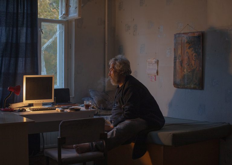 Санкт-Петербург, Россия - 21 октября 2023: Зафархон Мирсолиев курит у себя в комнате возле своего рабочего места, Санкт-Петербург.